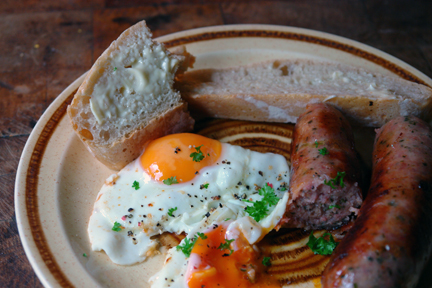 sliced, homemade ciabatta with fried eggs and Todmorden-made sausages