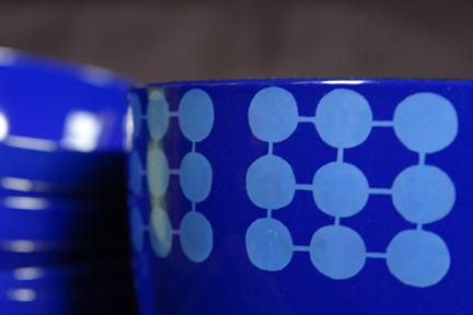 detailed view of a collection of blue vintage Finel enamel bowl decorated with circles in a square pattern