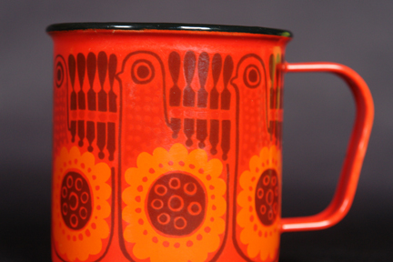detailed view of red, vintage Finel enamel mug decorated with repeating bird pattern