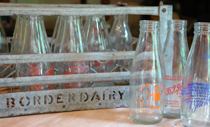 vintage metal milk crate with vintage milk bottles