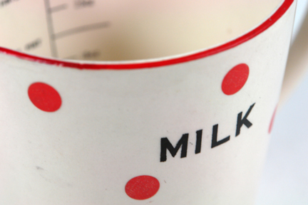 detail from a vintage 1950s red polka dot pottery milk jug