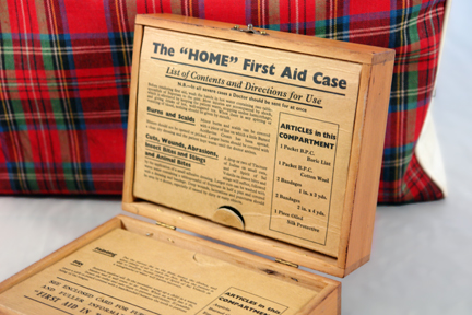 vintage wooden first aid box with lid open showing contents
