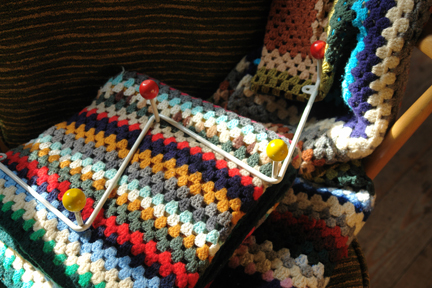 vintage hand crocheted woollen throws and wire atomic coat hooks