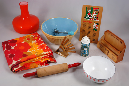 group of vintage items soon to be added to the H is for Home website including a medium sized orange & white Cathrineholm Lotus enamel bowl, wooden rolling pin with red handles, pottery mixing bowl with blue interior, orange cased glass light shade produced by Holmgaard, floral fabric in shades of orange, wooden shopping reminder board, wooden letter rack, set of wooden handled knives in a stand, pottery sifter made by Portmeirion and a metal swizzle stick with blue painted wooden handle
