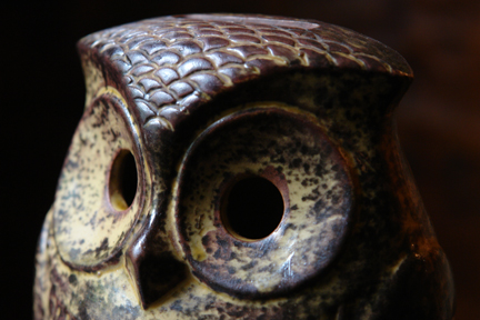 detail from a brown vintage pottery money box in the shape of an owl