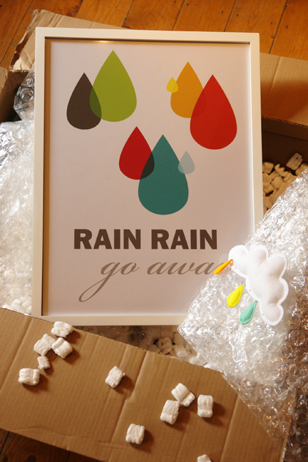 large cardboard box opened revealing rain rain, go away poster and mobile