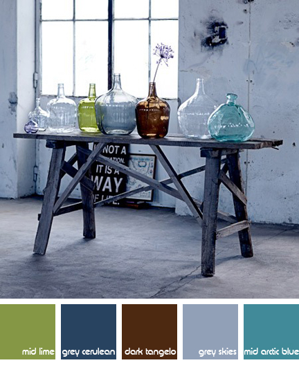 collection of vintage coloured bottles on an industrial trestle table
